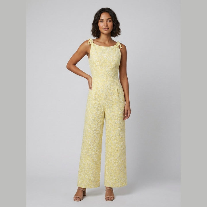 Yellow textured sleeveless jumpsuit with bow neckline, front view on model