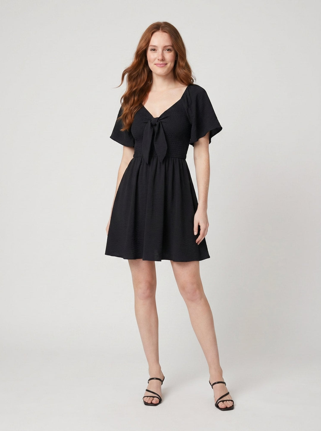 Charline V-neck mini dress with bow tie in black, front view on model