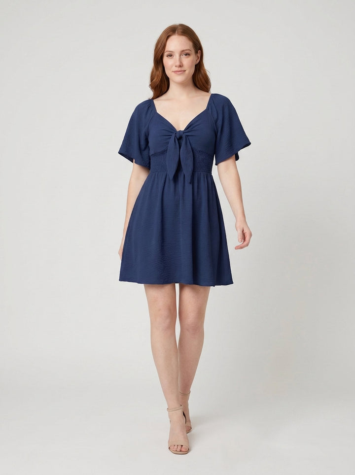 Charline V-neck mini dress with bow tie in navy blue, front view on model