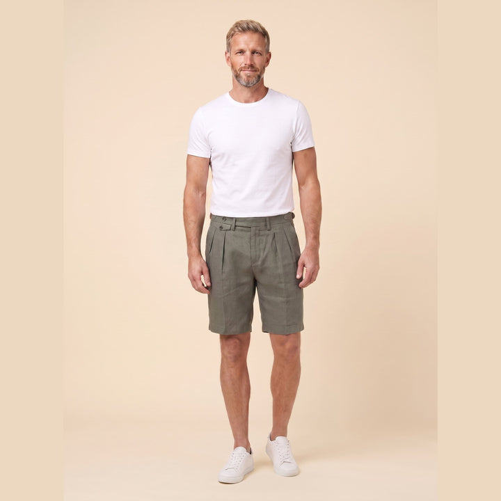 Man in olive linen pleated Linden Bermuda shorts, front view