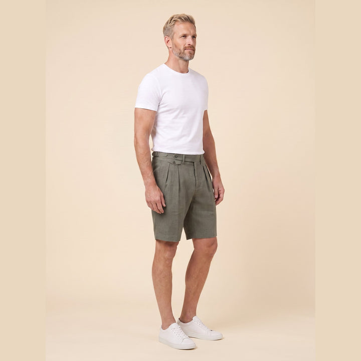 Olive linen Linden Bermuda shorts, side view on model