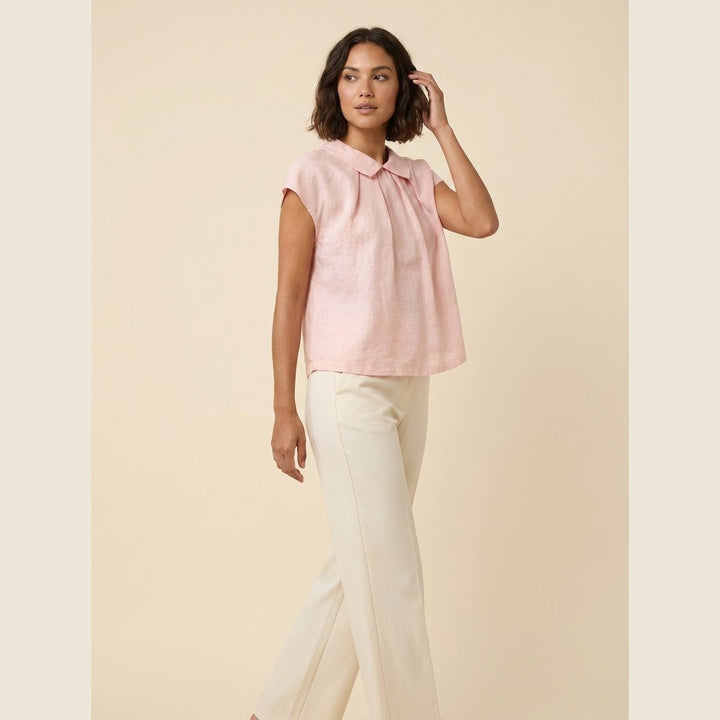 Pale blush linen pintuck top, three-quarter view on model
